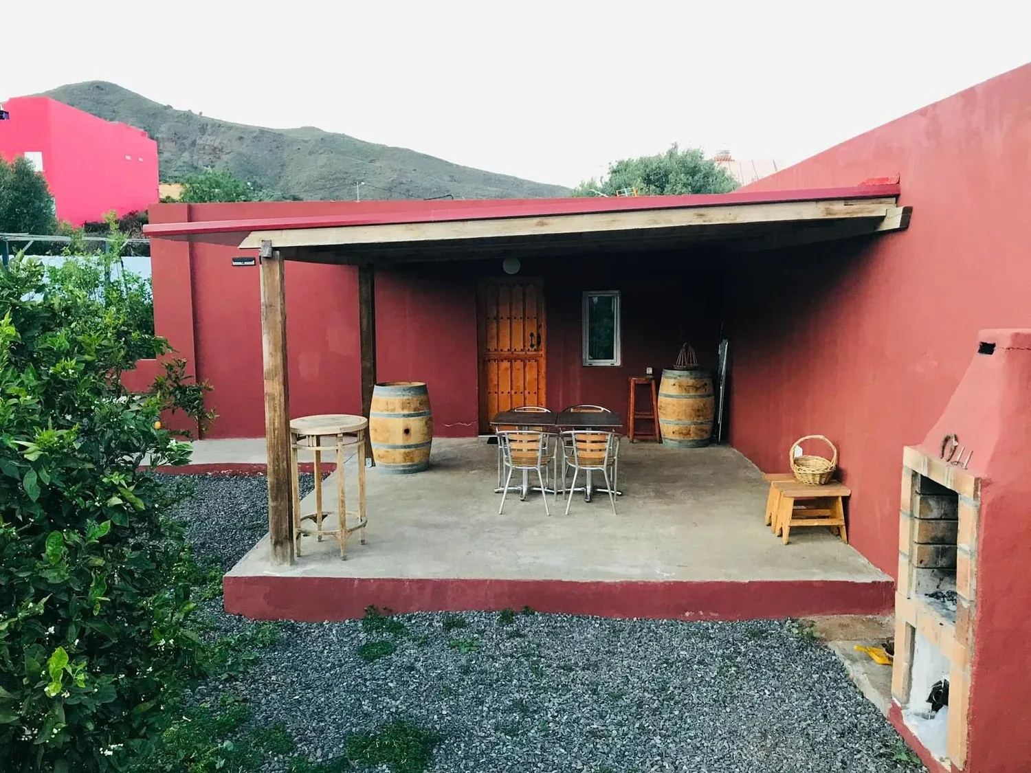 Porche reformado de una casa rural en Telde, con pérgola, mobiliario exterior y las montañas al fondo