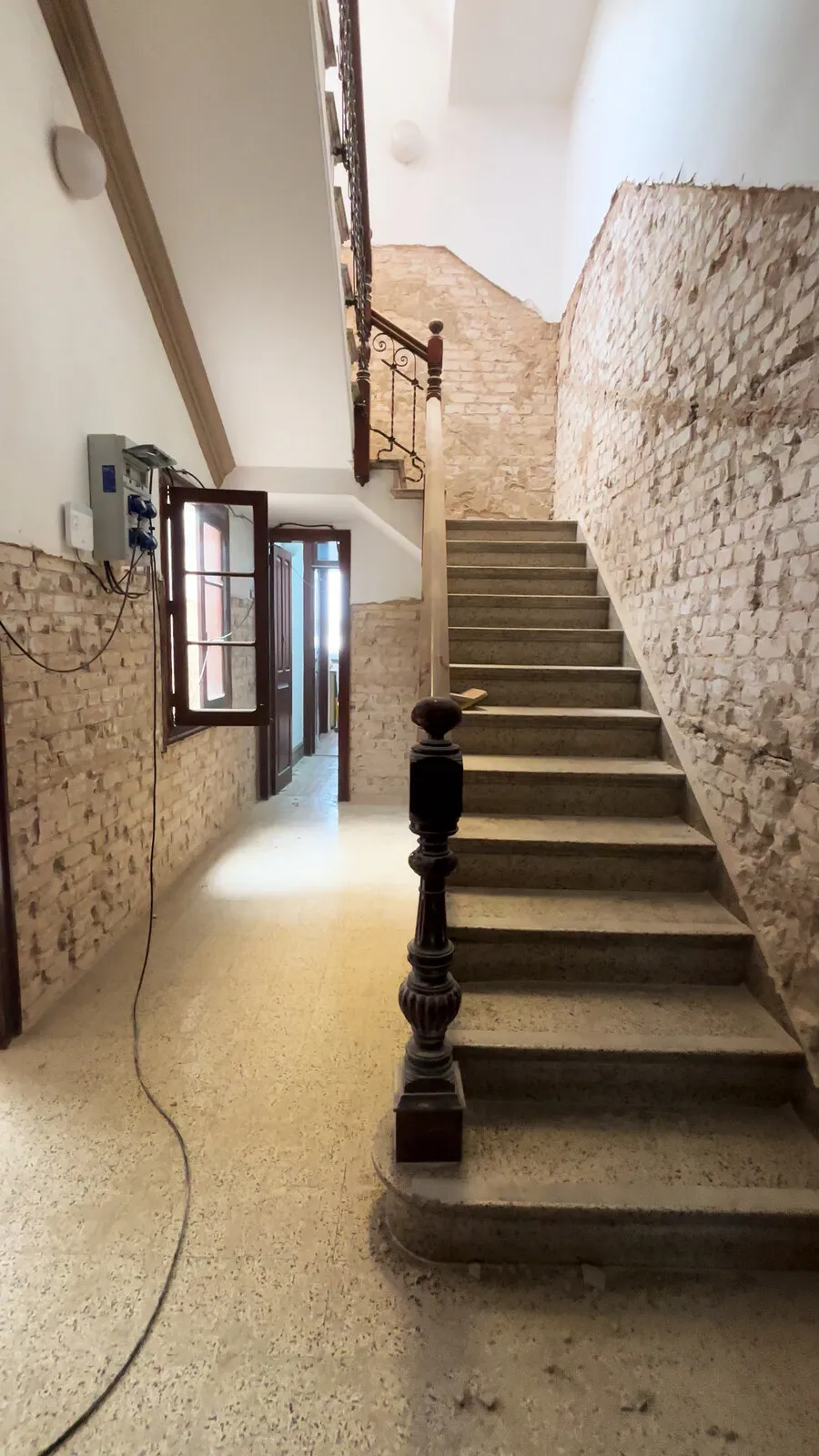 La escalera de piedra arranca en el zaguán